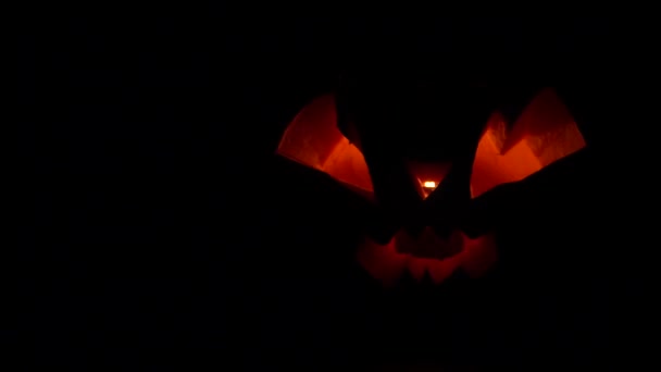 Зловещий Хэллоуин тыква мерцает красный адский свет в темноте — стоковое видео