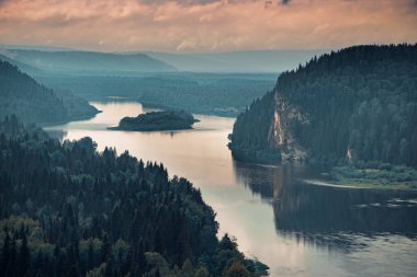 Nehrin kenarına uzanan kayalık bir kıyı manzarası.