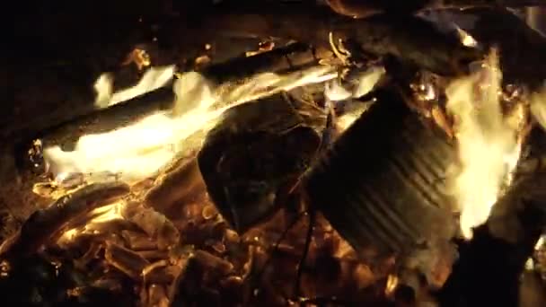 Збиті залізні банки лежать у вогні, в якому тепло високе — стокове відео