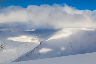 Taze kar, sis ve güzel ışık ile dağlarda dramatik kış manzarası