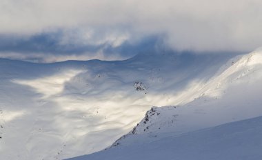 Taze kar, sis ve güzel ışık ile dağlarda dramatik kış manzarası
