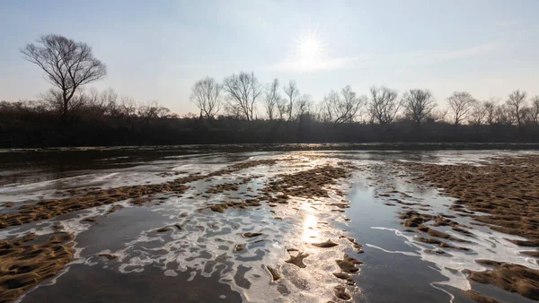 Kış manzarası, buzlu ve vahşi nehir kıyısında taze kar.