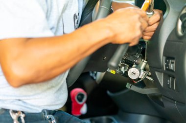 teknisyen tamir anahtarında tornavida ve çekiç kullanır veya sedan arabanın motorunu çalıştırır