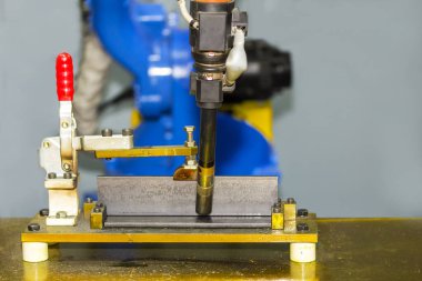 close up workpieces set up tee joint on table for electric mig welding process by robot at factory clipart