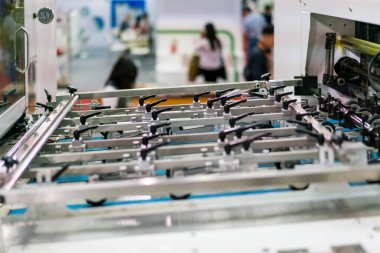 Otomatik yayın veya yazdırma makinesinin modern ve yüksek teknolojisinin detaylarını kapat ve paten besleme sistemini kapat