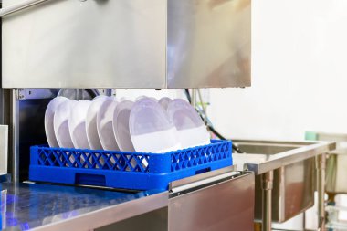 Sanayi için otomatik bulaşık makinesinde beyaz tabağı sepete kapat.