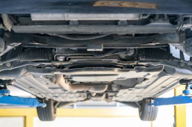 Garajdaki şasenin alt görüntüsü ve hidrolik direksiyon ve süspansiyon sistemi bakım için kaldırılıyor.