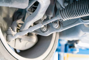 Otomobilin alt görünümü lades kemiği güç direksiyon kolu süspansiyonu ve garaj veya sedan araba sistemi bakım ya da servis için kaldırın