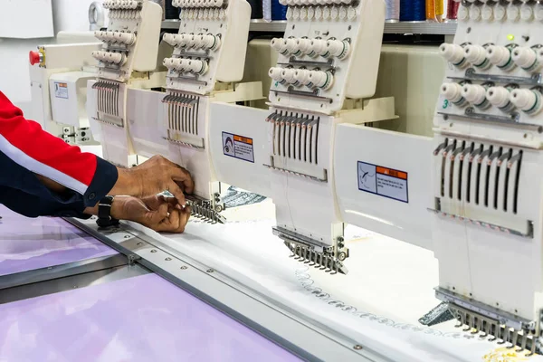 Sanayide tekstil veya giysi imalatı için modern ve otomatik yüksek teknoloji dikiş makinesi üzerinde çalışan operatör veya terzi