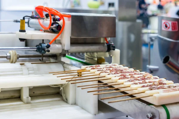 工业化生产用自动刺或刺猪肉机支撑架上的亚洲烧烤或猪肉棒 — 图库照片