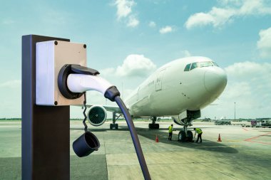 Fişi ve elektrik kablosu olan elektrik uçak şarj istasyonu mavi gökyüzü arka planlı kargo ya da uçak parkında