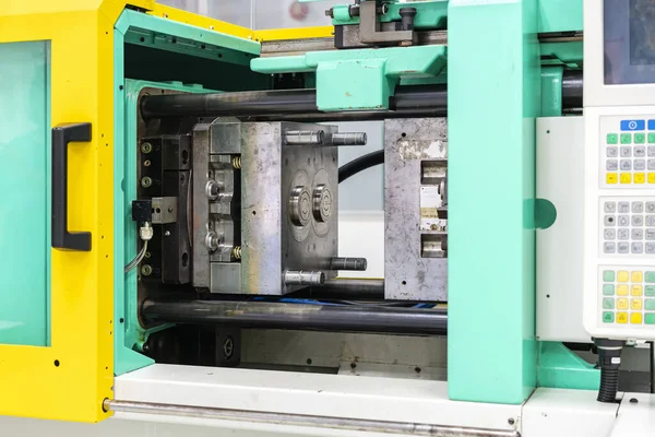 metal mould or plastic injection mold setup on high pressure injection molding machine for mass production or manufacturing in industrial and touch screen foreground