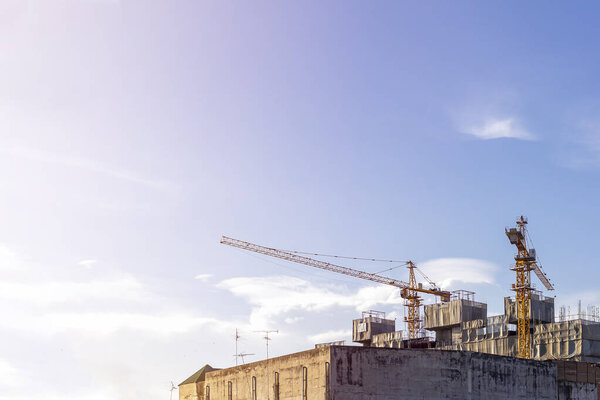 A huge crane at hotel or condo building construction site with blue sky and sunshine