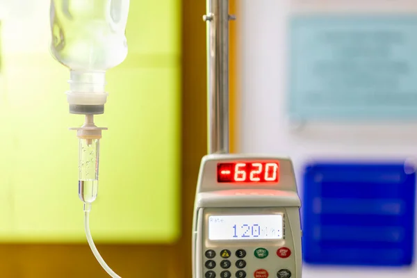 Iv drip irrigation transparent infuses fluids medication or nutrients and sodium chloride or saline solution fluid hang on stand with automatic infusion pump in room at hospital
