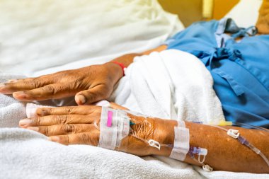 Hastanın el ve serum tüplerine odaklan. Ya da hastane koğuşundaki hastaya. Damar içi tuz çözeltisi dozu sırasında yatağa uzan. 