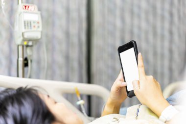 Kadın hastalar cep telefonu kullanır ve damardan tuz çözeltisi dozu sırasında hastanede yatar. Cep telefonunda tıbbi ve vitamin seçici odak noktası.