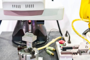 Teftiş sırasında otomatik koordinat ölçüm makinesi (CMM), robot kolu ve otomatik tutuş klempi ile üretim sürecinde endüstriyel motor için hassas bölümdür.