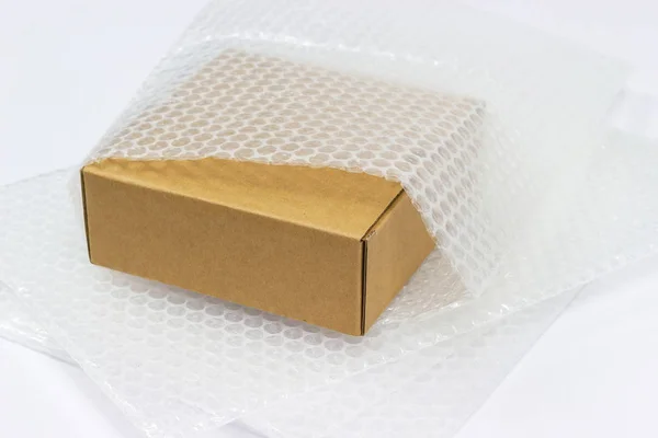 保护产品的气泡包装在褐色箱子破裂或保险在运输概念期间保护产品 — 图库照片