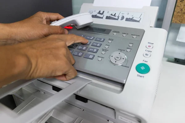 hand man are using a fax machine in the office. Business concept