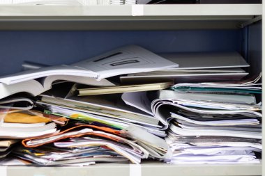 Çalışma ofisindeki dosya dolaplarında dağınık dosya ve ofis malzemeleri 