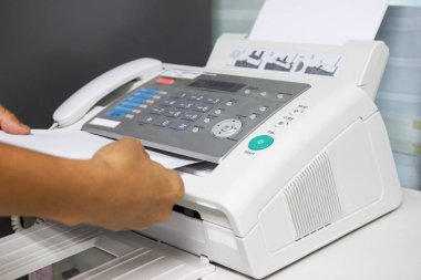 Elini adam ofiste bir faks makinesi kullanarak. İş kavramı 