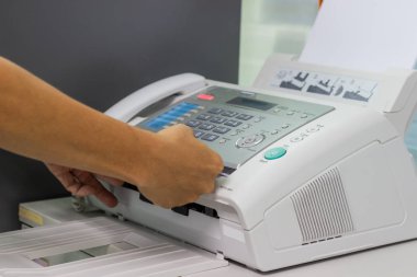Elini adam ofiste bir faks makinesi kullanarak. İş kavramı 