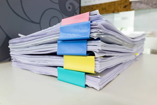 Stack of papers documents in archives files with paper clips on desk at offices, business concept.