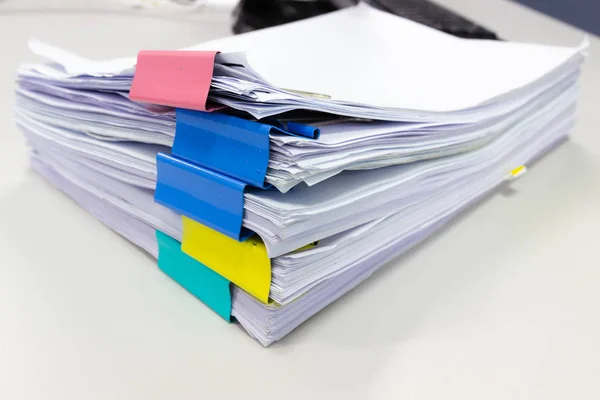 Stack of papers documents in archives files with paper clips on desk at offices, business concept.