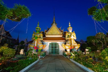 WAT Arun Raj Tharam Bangkok Tayland - onların batons Tapınağı girişinin önünde tutan iki dev heykeller. Dev yeşil Todsagun Ramayana dev beyaz millenium görkemi.