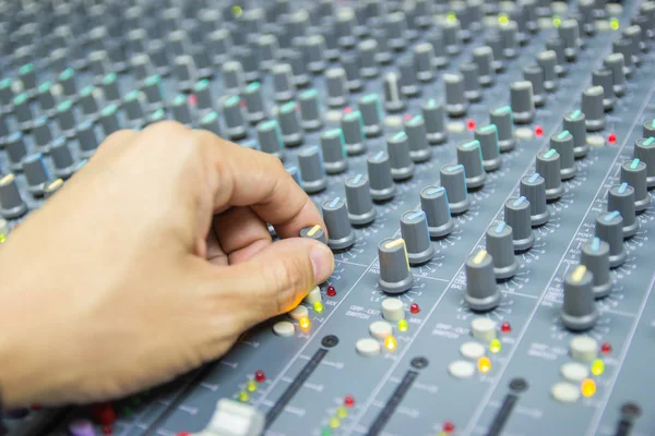 Close-up hand of man control Mixing Console of a big HiFi system The audio equipment, control panel of digital studio mixer.