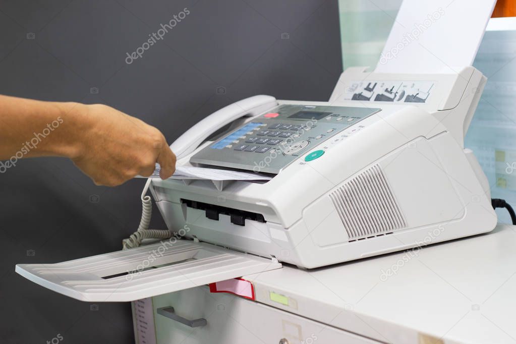 hand man are using a fax machine in the office Business concept office life