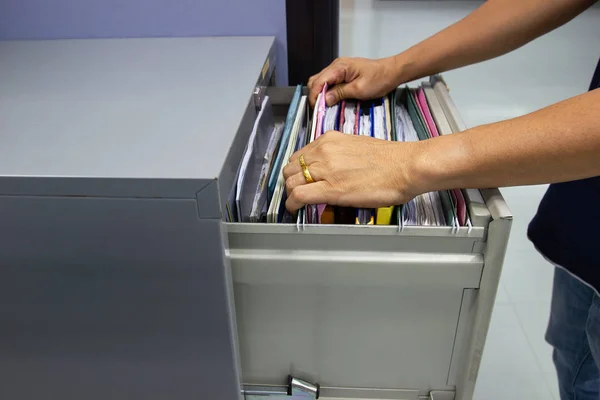 Hand of Man Search files document in a file cabinet in work office, concept office life.