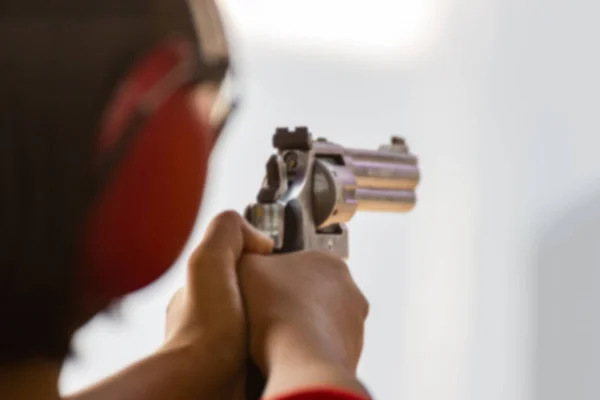 Hand of men hold a gun ready to shoot  practicing shooting in the park selective focus on the back part of gun