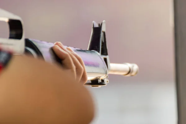 Han of people hold a gun ready to shoot  practicing shooting at Shooting Range and selective focus on the back part of gun