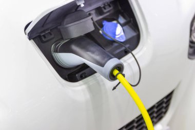 Aracın aküsünü şarj etmek yeni otomotiv yenilikleri şarj edilen elektrikli bir arabaya takılan güç kaynağı, enerji yeniliği kavramı..