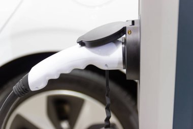 Aracın aküsünü şarj etmek yeni otomotiv yenilikleri şarj edilen elektrikli bir arabaya takılan güç kaynağı, enerji yeniliği kavramı..