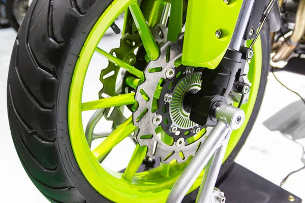 Detail Motorcycle wheel in black and green with ABS brakes part of the motorcycle.