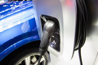 Aracın aküsünü şarj etmek yeni otomotiv yenilikleri şarj edilen elektrikli bir arabaya takılan güç kaynağı, enerji yeniliği kavramı..