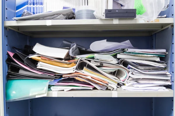 Çalışma ofisindeki dosya dolaplarında dağınık dosya ve ofis malzemeleri 