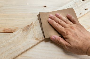 Worker Man Polishing Sandpaper Wood by hand. clipart