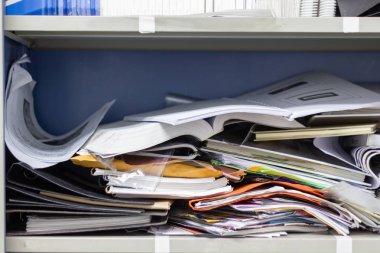 Çalışma ofisindeki dosya dolaplarında dağınık dosya ve ofis malzemeleri 