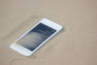 Sahilde denize yüzen beyaz cep telefonu.