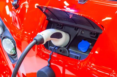 Aracın aküsünü şarj etmek yeni otomotiv yenilikleri şarj edilen elektrikli bir arabaya takılan güç kaynağı, enerji yeniliği kavramı..