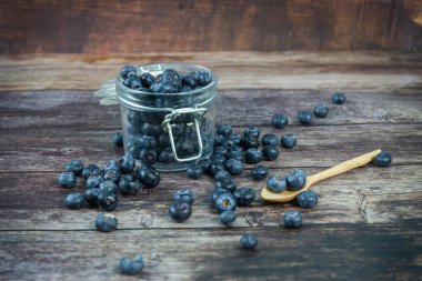 Ahşap masada cam Şişe Taze yaban mersini 