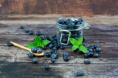 Ahşap masada cam Şişe Taze yaban mersini 