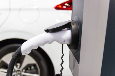 Aracın aküsünü şarj etmek yeni otomotiv yenilikleri şarj edilen elektrikli bir arabaya takılan güç kaynağı, enerji yeniliği kavramı..