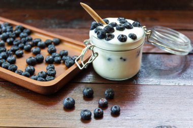 ahşap masalarda cam yoğurt ile taze Yaban Mersini