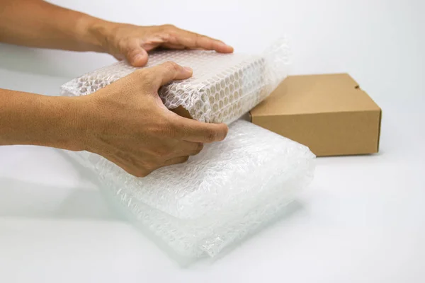 Hand van de mens houden bubble wrap, voor bescherming Parcel product — Stockfoto