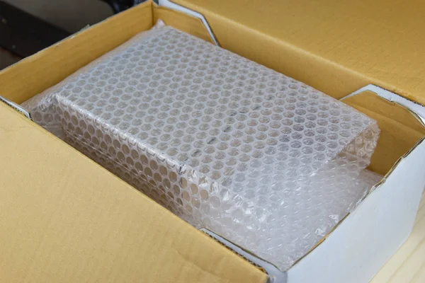 Bubliny zakrývající krabici pomocí bublinového obalu pro ochranný přípravek — Stock fotografie