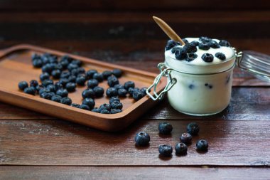 ahşap masalarda cam yoğurt ile taze Yaban Mersini